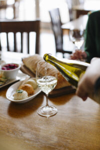 Riesling being poured in to a glass on a table.