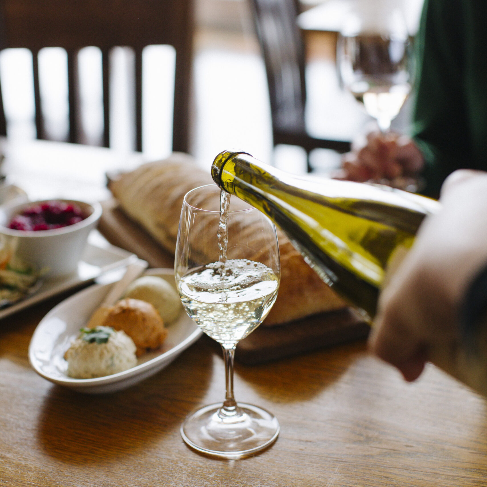 Riesling being poured in to a glass on a table.