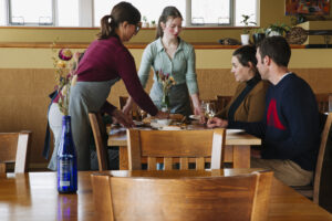 People serving wine and food.